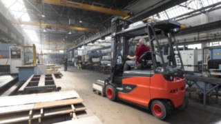 Eine Gruppe von Personen analysiert die Arbeitsumgebung in einer Logistikhalle.