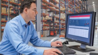 Flottenmanagement mit Linde connect. Flottenmanager vor einem Desktop mit Linde connect, dem Flottenmanagementsystem von Linde Material Handling.