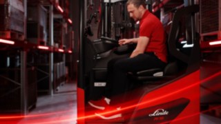 Seitenansicht eines Bedieners bei der Arbeit im ergonomischen Linde MH-Schubmaststapler Ri16.