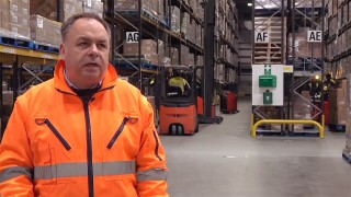 Mann in Warnkleidung im Lager
